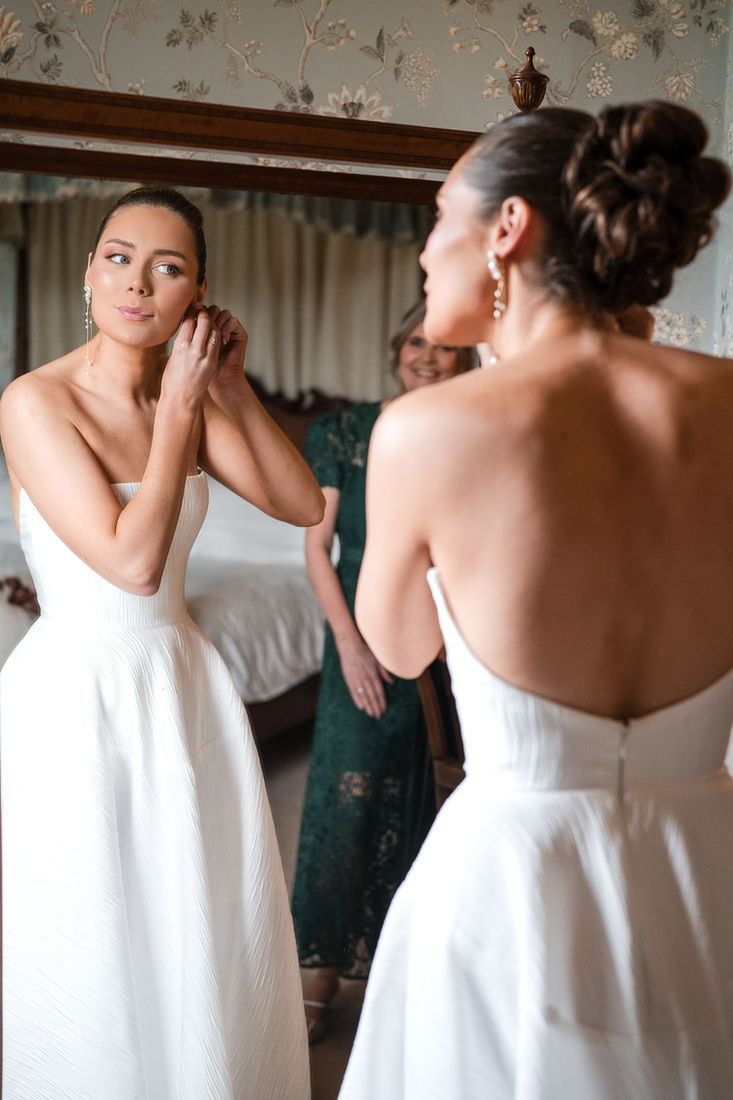 Bride getting ready with her bridesmaid before the ceremony