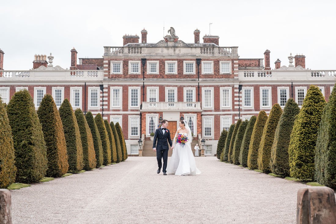 Bride and groom on the steps of a stately home's wooden doorway