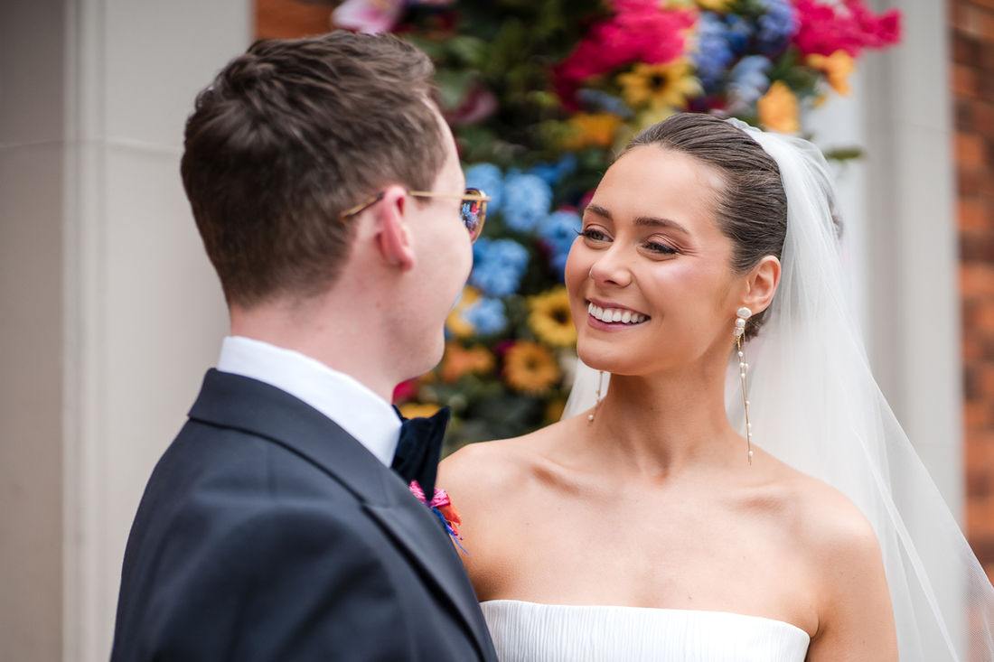 Groom seeing his bride for the first time, flowers behind them